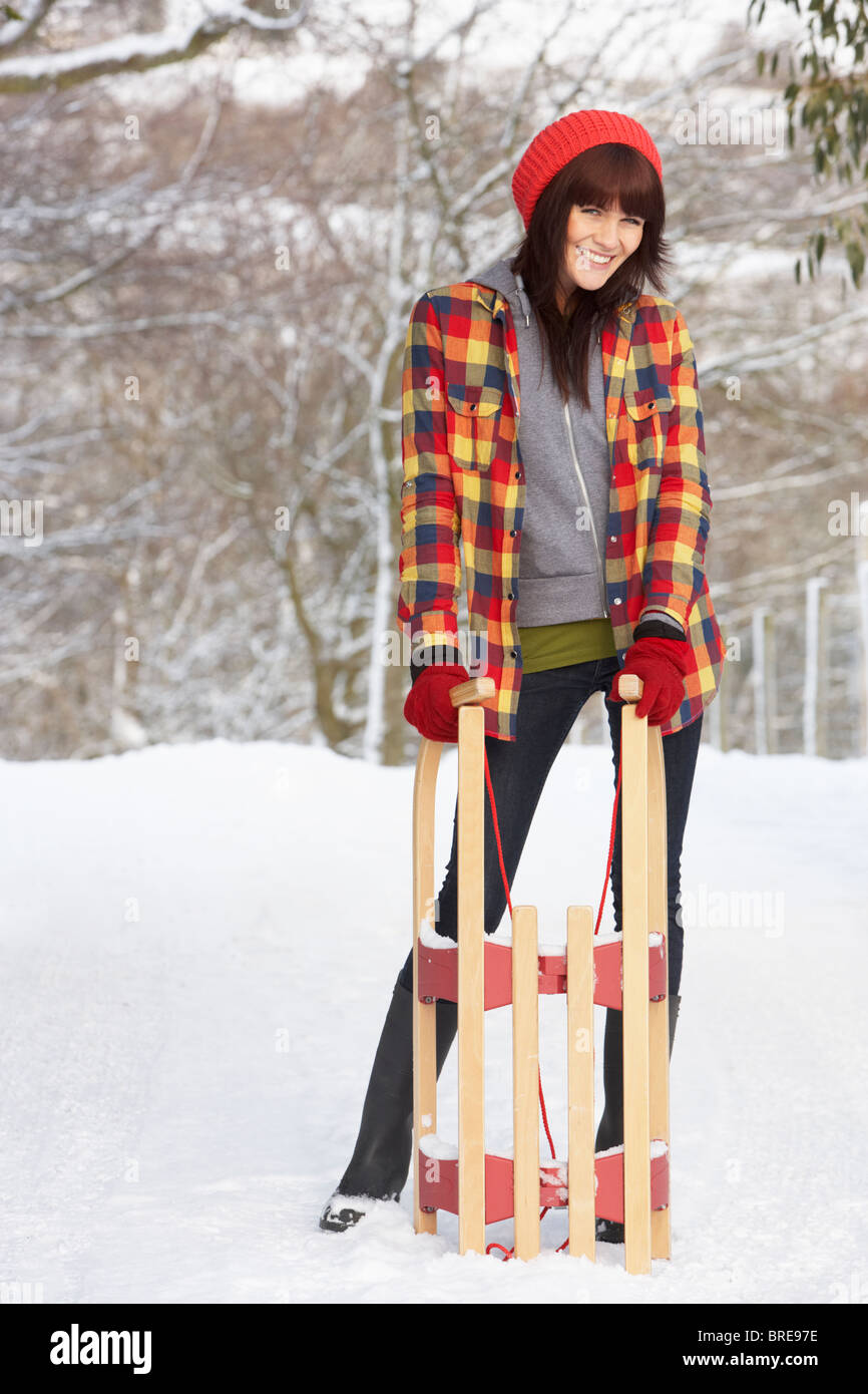 Frau mit Schlitten In Schneelandschaft Stockfoto
