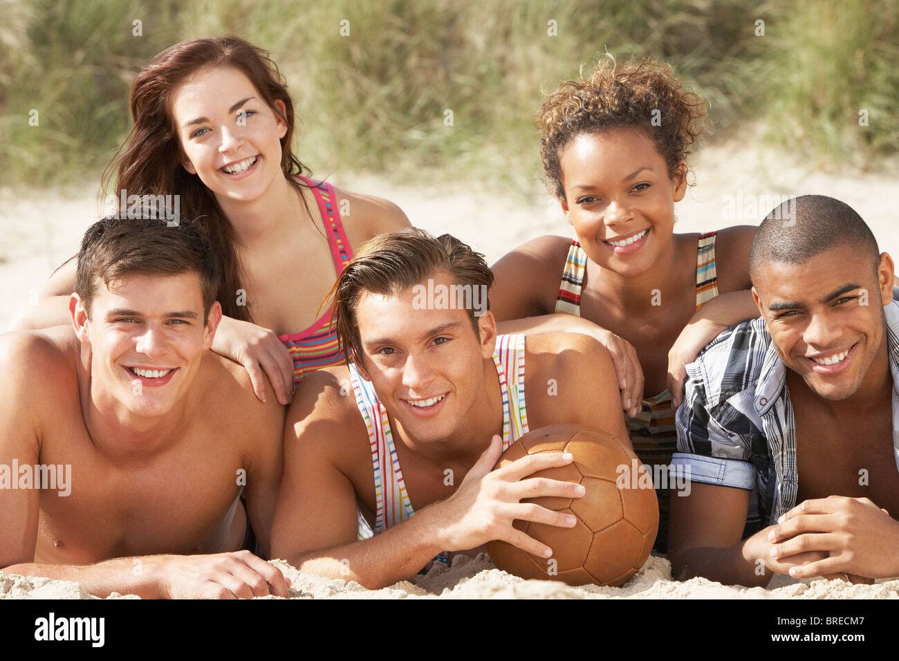 Gruppe von Freunden am Strand mit dem Fußball zusammen entspannen Stockfoto