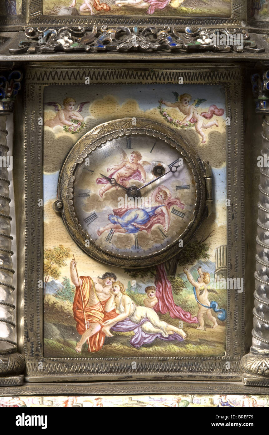 Eine emaillierte Manteluhr, Wien, Spindeluhr aus dem frühen 19. Jahrhundert, Platten signiert "Anton Brandl in Wien". Emaillierte Uhrenfläche, römische Ziffern und Kamberglas. Das Gehäuse ist aus silberfarbenem und feinem 'Scharffeuer'-Email, das antike Szenen zeigt. Der obere Teil des Gehäuses wird von vier mit silbernem Draht gewickelten Kristallsteinsäulen getragen, über denen sich vier skulptierte weibliche Genii befinden. Überragt von einer Figurengruppe des Erzengels Michael, der den Drachen erschlägt. Das Silber etwas getrübt, ein Chip an der Basis der Michael-Figur, die Uhrwerke nicht, Stockfoto