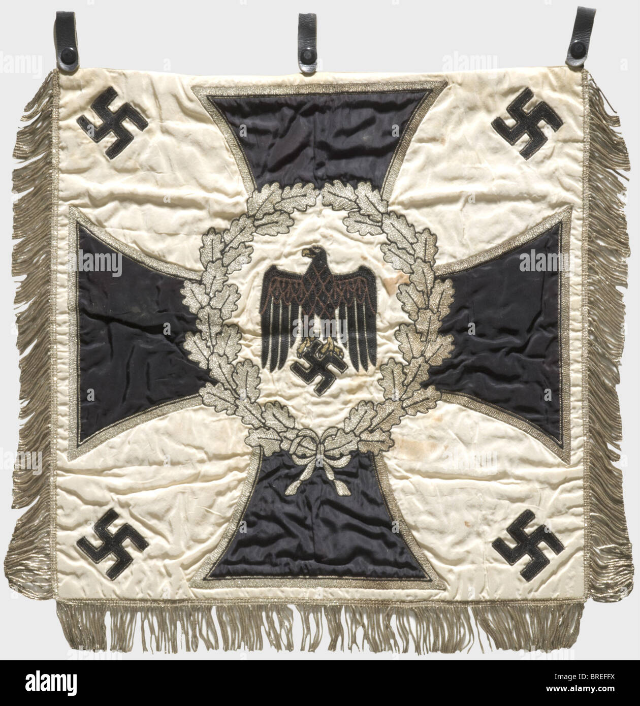 Ein Trompetenbanner des 1. Battalion/12. Infantry Regiment weißes Seidentuch mit einem in Schwarz und Braun bestickten Armeeadler, umgeben von einem silberbestickten Eichenblattkranz über einem eisernen Kreuz und vier aufgebrachten Hakenkreuzen in den Ecken. An drei Seiten silberne Fransen. Drei Lederschlaufen. Auf der Rückseite der silbergestickte Einheitenname. Abmessungen ca. 53 x 56 cm. Leicht gefleckt, ansonsten in sehr gutem Zustand mit hellen Farben. Von großer Seltenheit: Historisch, historisch, 1930er, 1930er, 20. Jahrhundert, Infanterie, Militär, Streitkräfte, Militaria, Objekt, Stockfoto