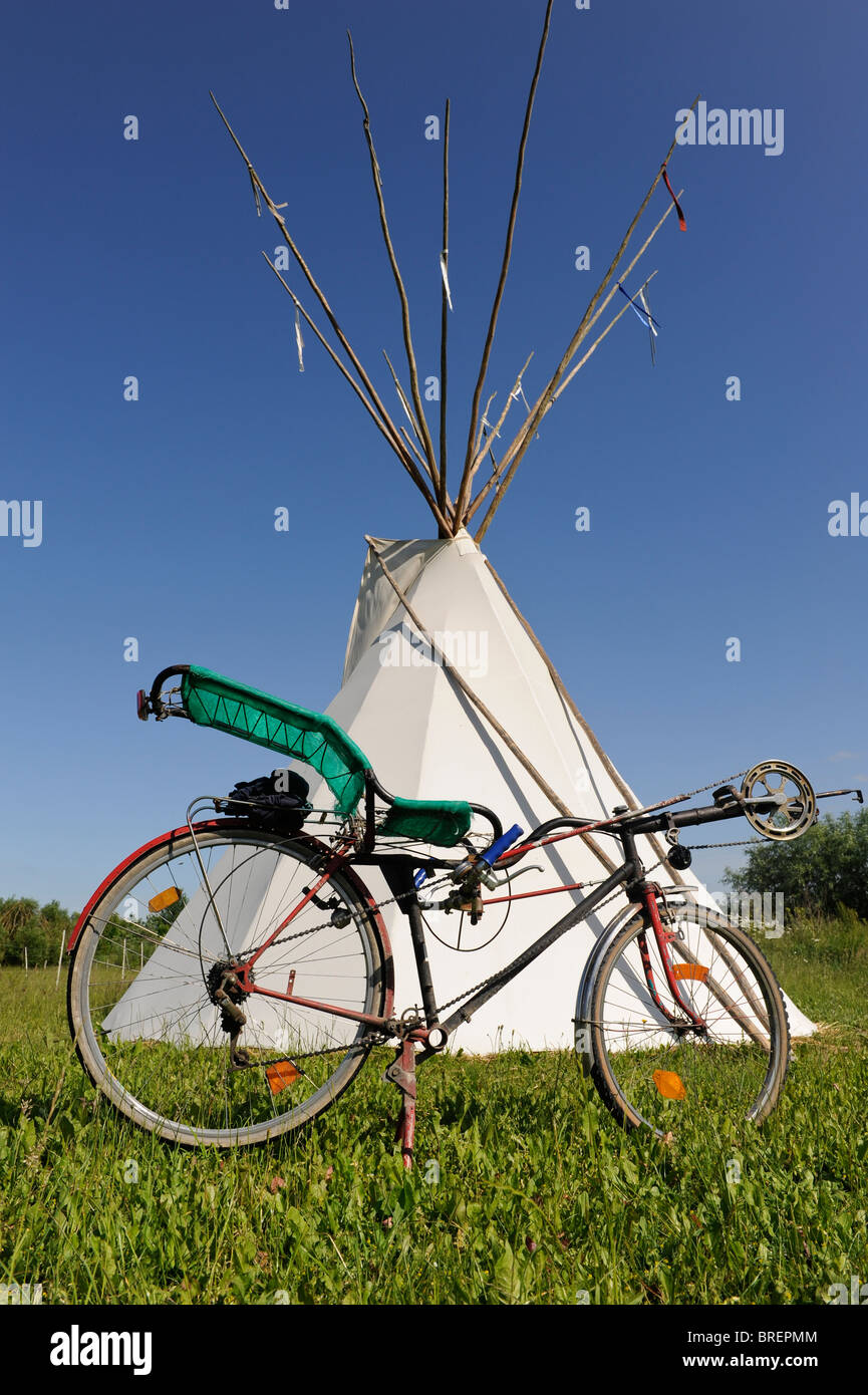 Deutschland, Öko-Dorf Siebenlinden, rotes indisches Tipi-Zelt und Fahrrad in der Natur legen Stockfoto