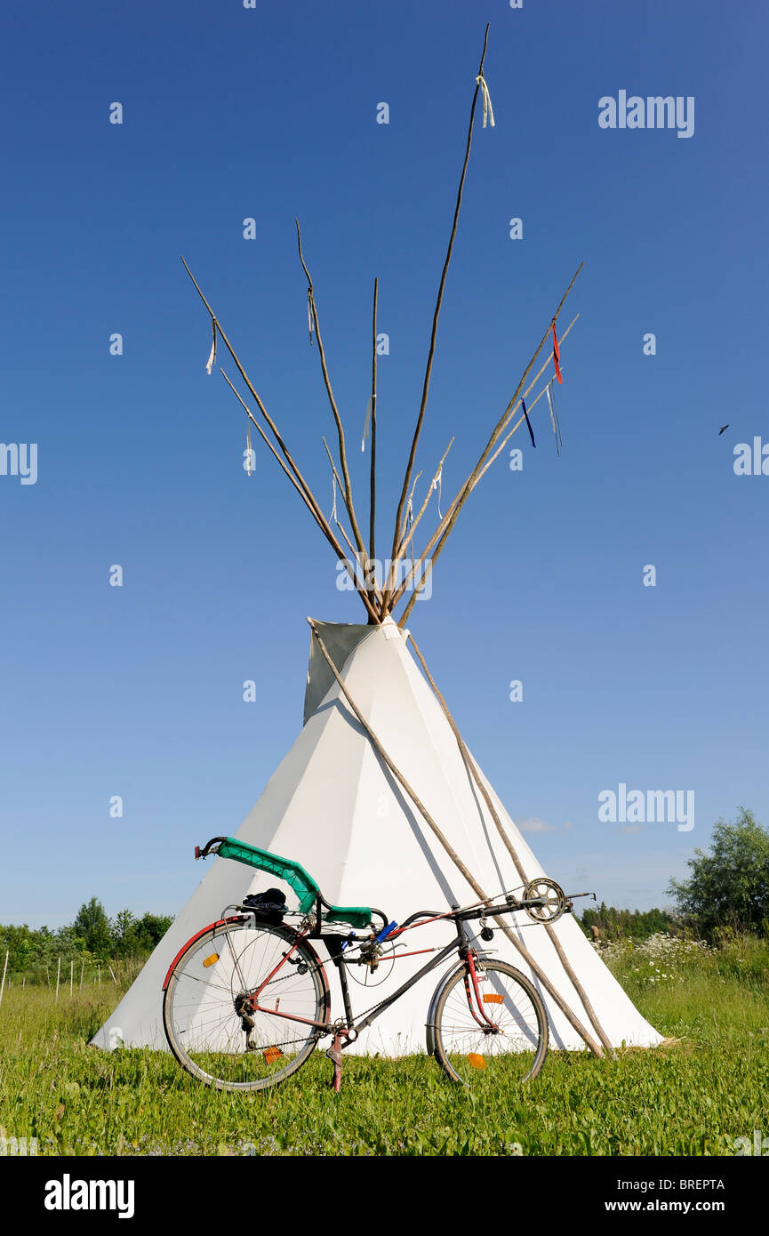 Deutschland, Öko-Dorf Siebenlinden, rotes indisches Tipi-Zelt und Fahrrad in der Natur legen Stockfoto