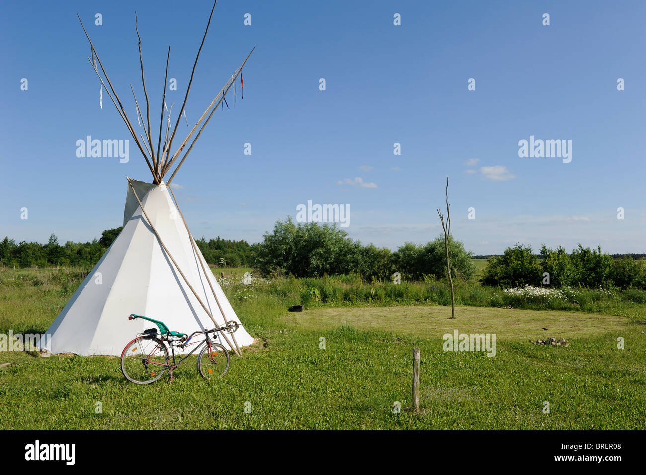 Deutschland, Öko-Dorf Siebenlinden, rotes indisches Tipi-Zelt und Fahrrad in der Natur legen Stockfoto