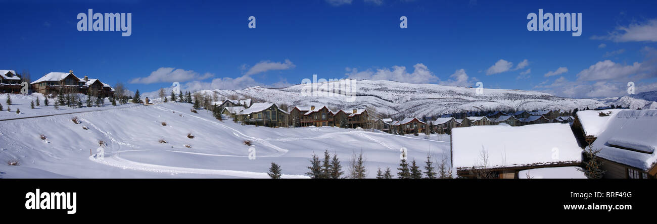 Panorama: sanfte Hügel, Koniferen und große Häuser, Winterschnee in Cordillera, Colorado Stockfoto