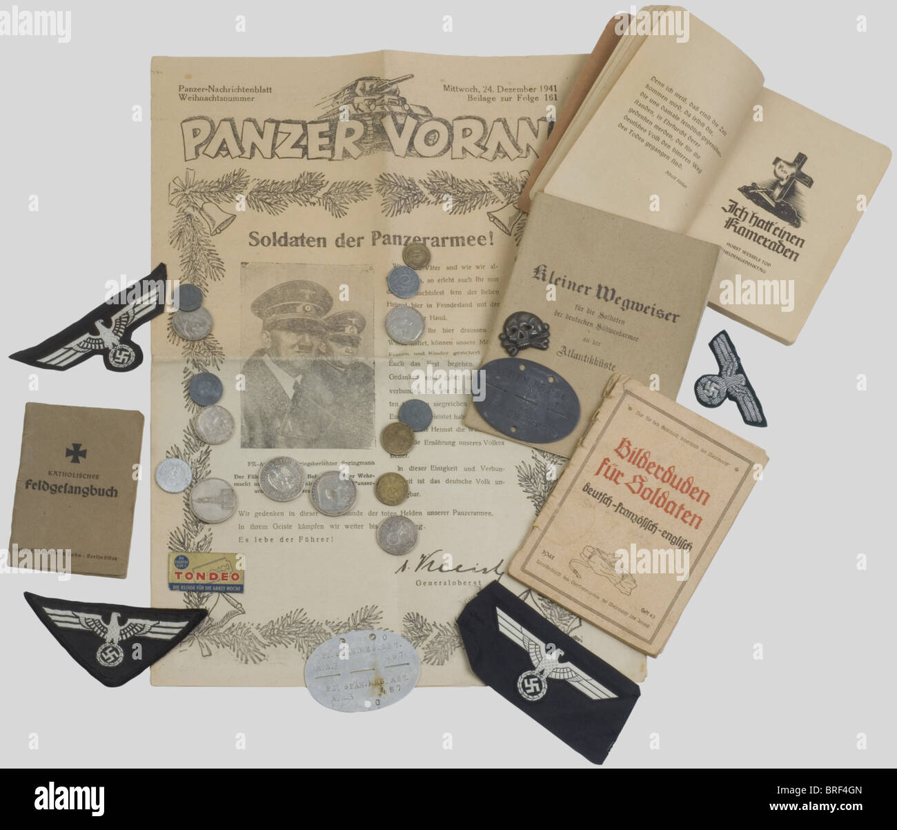 Wehrmacht, Ensemble de divers équipements de la Wehrmacht, comportant trois aigles bévo troupe du Premier modèle sur Fond noir, un aigle de coiffure en cannetille argent sur Fond vert, une tête de mort en métal dite 'danzig' pour Casquette de Tradition, Deux plaques d'identité militaires dont l'une d'un Régiment de Panzertruppe, quatre livrets, un Journal 'Panzer Voran' et quinze pièces de monnaie diversen., , Stockfoto