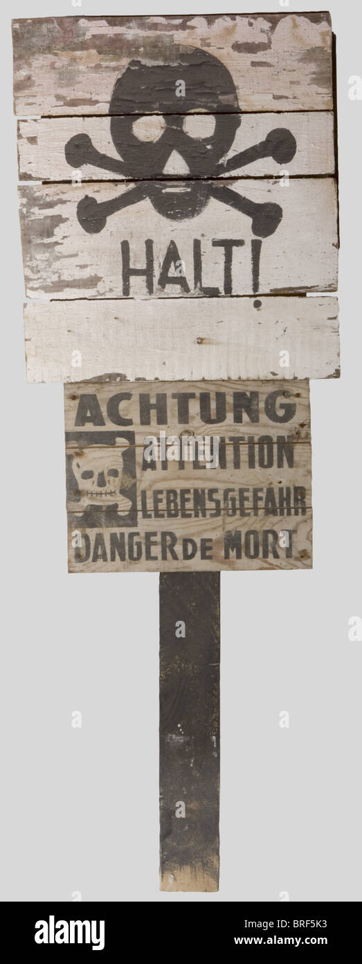 Wehrmacht, Deux panneaux de signalisation Antimines, rectangulaire, en bois. UN signalant un champ de mines en figurant une tête de mort peinte en noir et l'inscription 'HALT', long pied de bois blanc restaure, panneau en trois parties, simicles 56 x 50 cm. L'autre avec en lettrage noir 'Achtung-Attention-Lebensfahr-Sanger de mort' avec une tête de mort et deux tibias entrecroisés sur Fond blanc. CES deux panneaux proviennent des Zones de Combat de la Poche de Royan., , Stockfoto