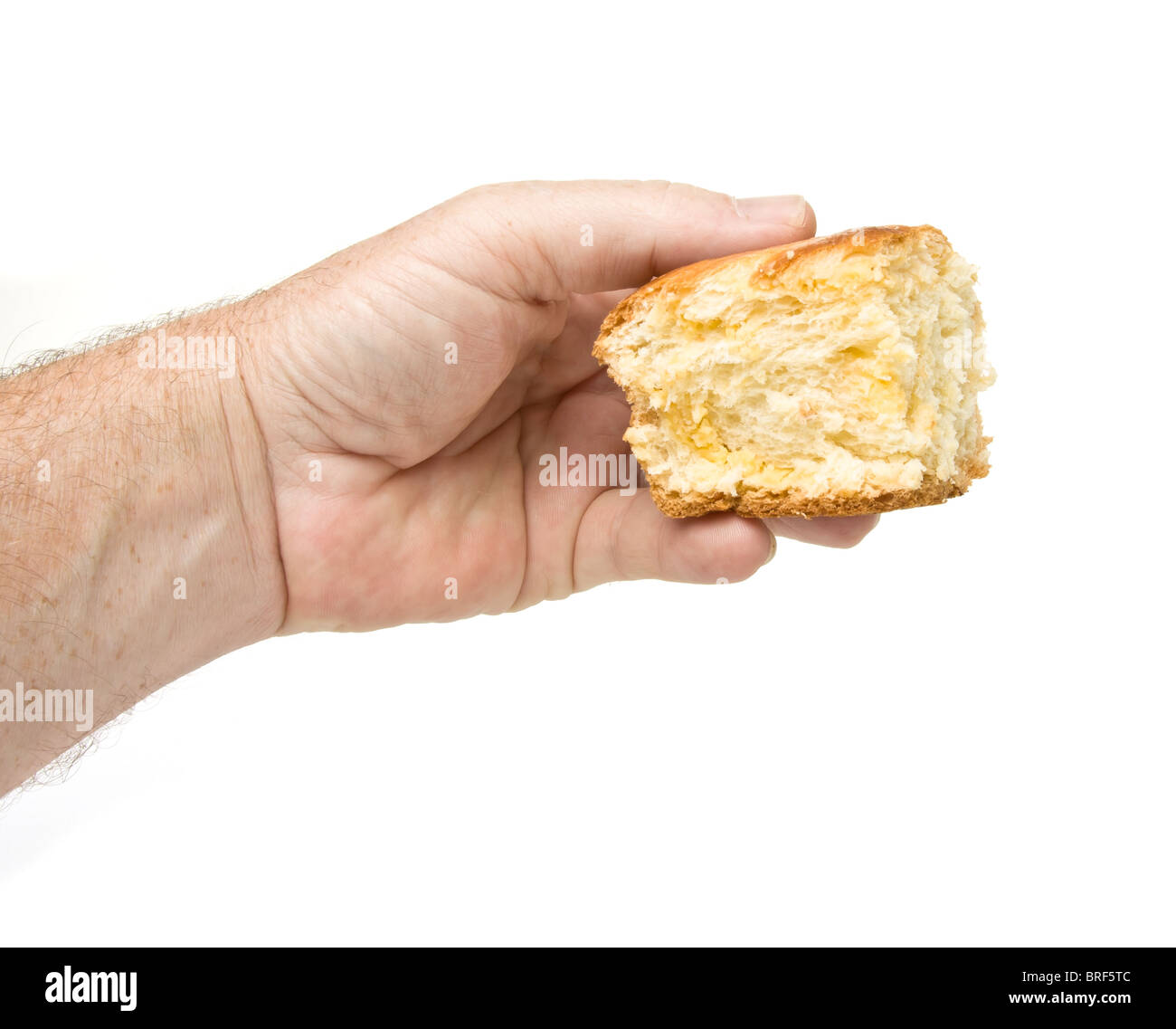 Männliche Hand hält Stück Brioche mit Creme Pudding isoliert auf weiss geschnürt. Stockfoto