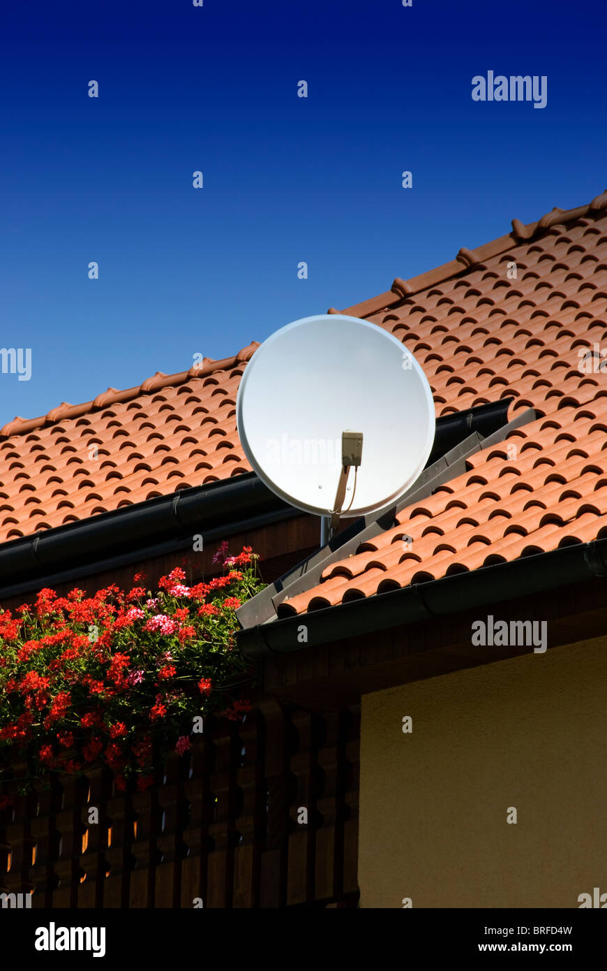 Satellitenschüssel auf dem Dach eines neuen Hauses Stockfoto