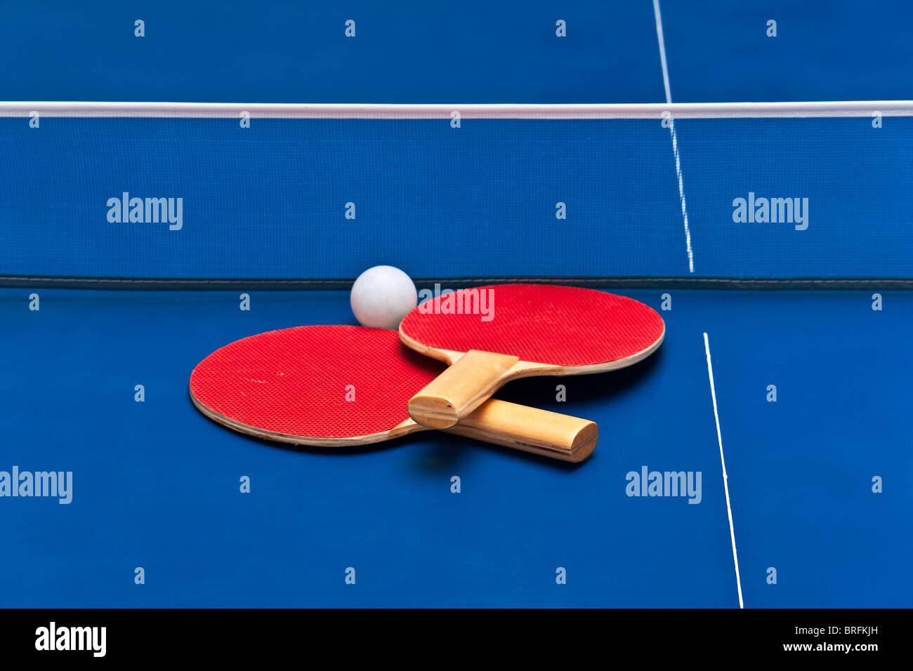 Paar Tischtennisschläger über einem blauen Spielfeld Stockfoto