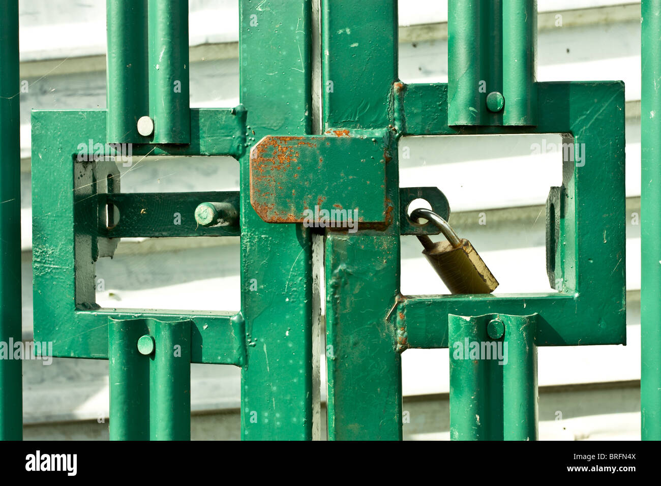 Schloss auf grüne verrosteten Heavy-Metal-Gates Sicherheitskonzept. Stockfoto