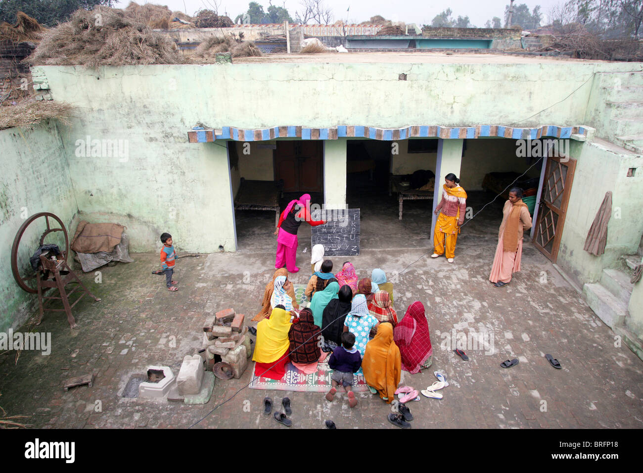 Mädchen mit einem informellen Schulstunde außerhalb, Rampur Region, Uttar Pradesh, Indien. Stockfoto