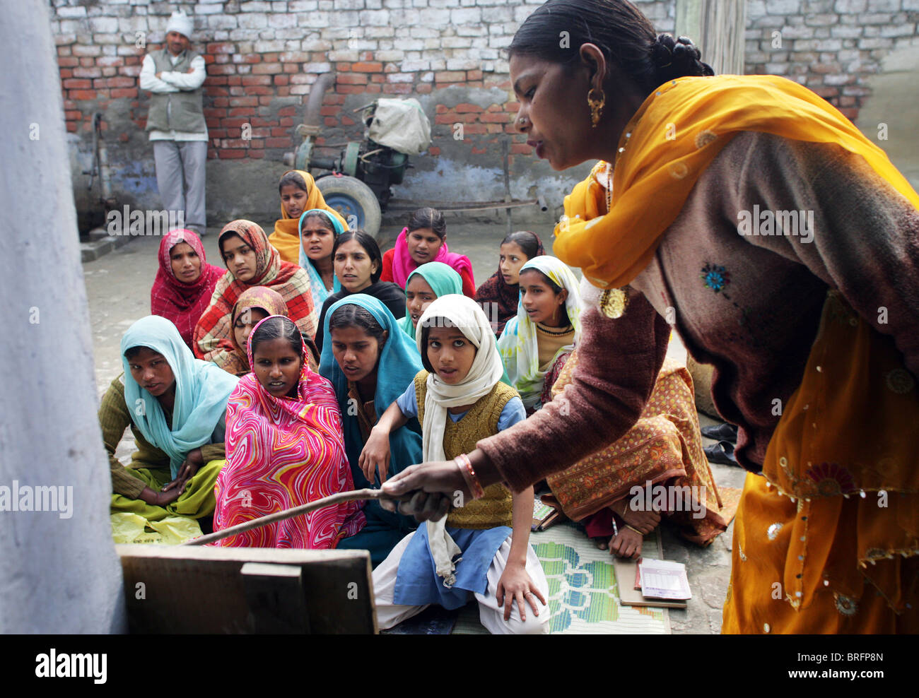 Mädchen mit einem informellen Schulstunde außerhalb, Rampur Region, Uttar Pradesh, Indien. Stockfoto