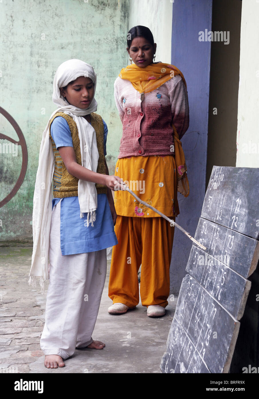 Mädchen mit einem informellen Schulstunde außerhalb, Rampur Region, Uttar Pradesh, Indien. Stockfoto