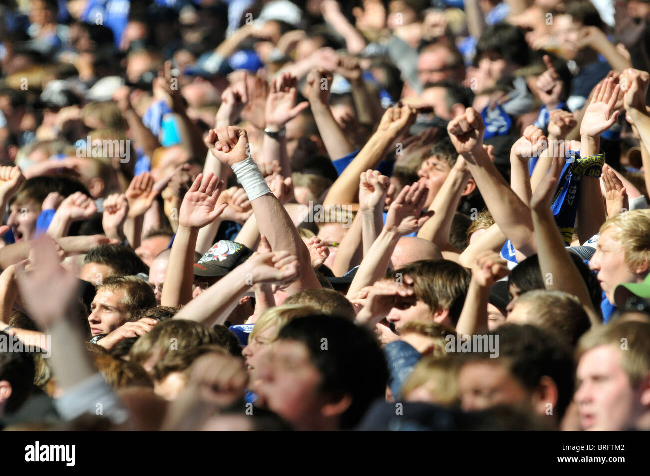 Fans der deutschen Fußball-Clubs Schalke 04 erheben ihre Hände in die Luft Stockfoto