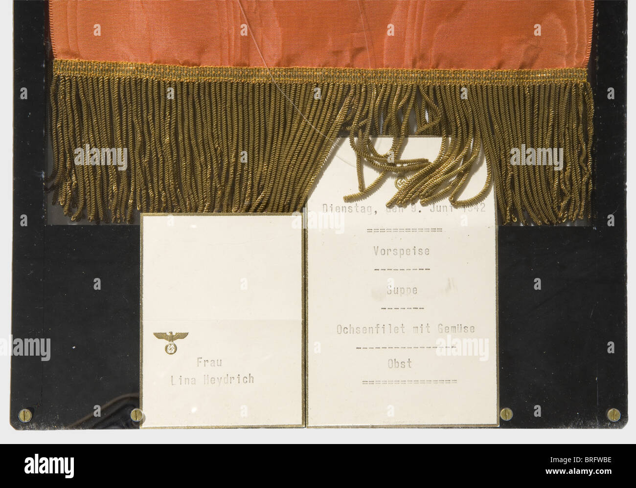 Adolf Hitler - Kranzband für die Trauerfeier für Reinhard Heydrich am 9. Juni 1942 im Mosaiksaal der Kanzlerei des Neuen Reiches in Berlin.Rote, bewässerte Rippseide mit Hitlers persönlichem Wappendorber, der in Gold auf die gestempelte Goldinschrift gestickt ist.der Führer und Oberste Behelfer der Wehrmacht (der Führer und Oberbefehlshaber der Wehrmacht).auf der gegenüberliegenden Seite ist Hitlers persönlicher Standard als Oberbefehlshaber der Wehrmacht in Gold auf Seide gestickt.EIN goldener Rand entlang der unteren Kante.Länge ca. 110 cm.herausragend, Zusatzrechte-Clearences-nicht verfügbar Stockfoto