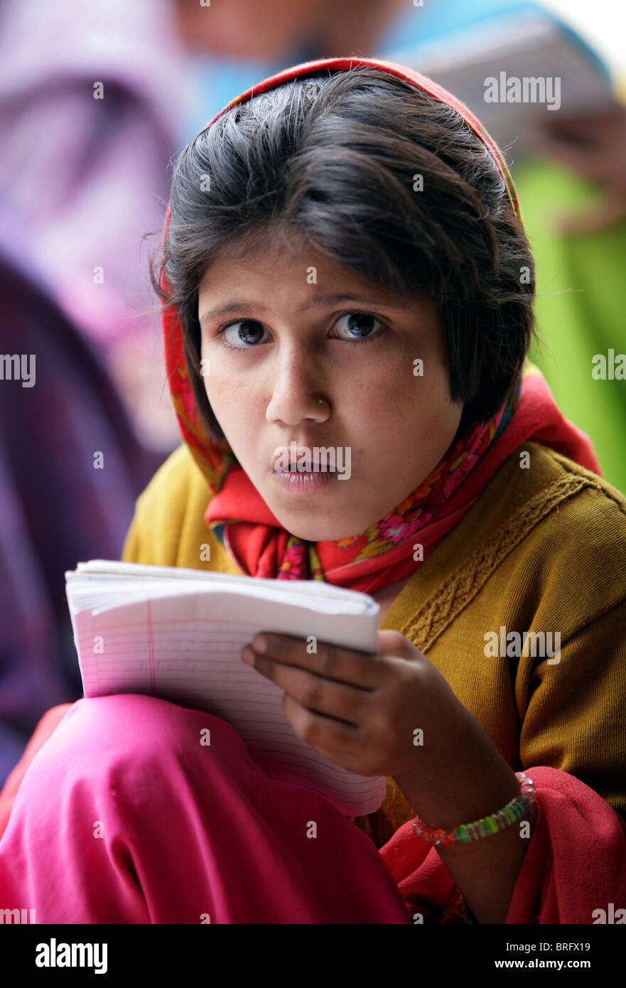 Mädchen mit einem informellen Schulstunde außerhalb, Rampur Region, Uttar Pradesh, Indien. Stockfoto