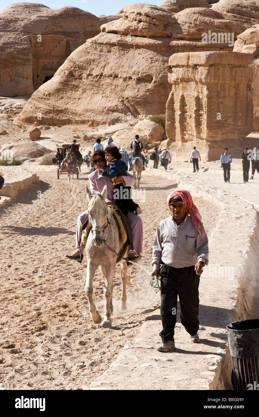 Touristen auf Reiten an den Siq, Canyon Eingang zum alten Felsen geschnitzt Stadt Petra, Jordanien. Stockfoto
