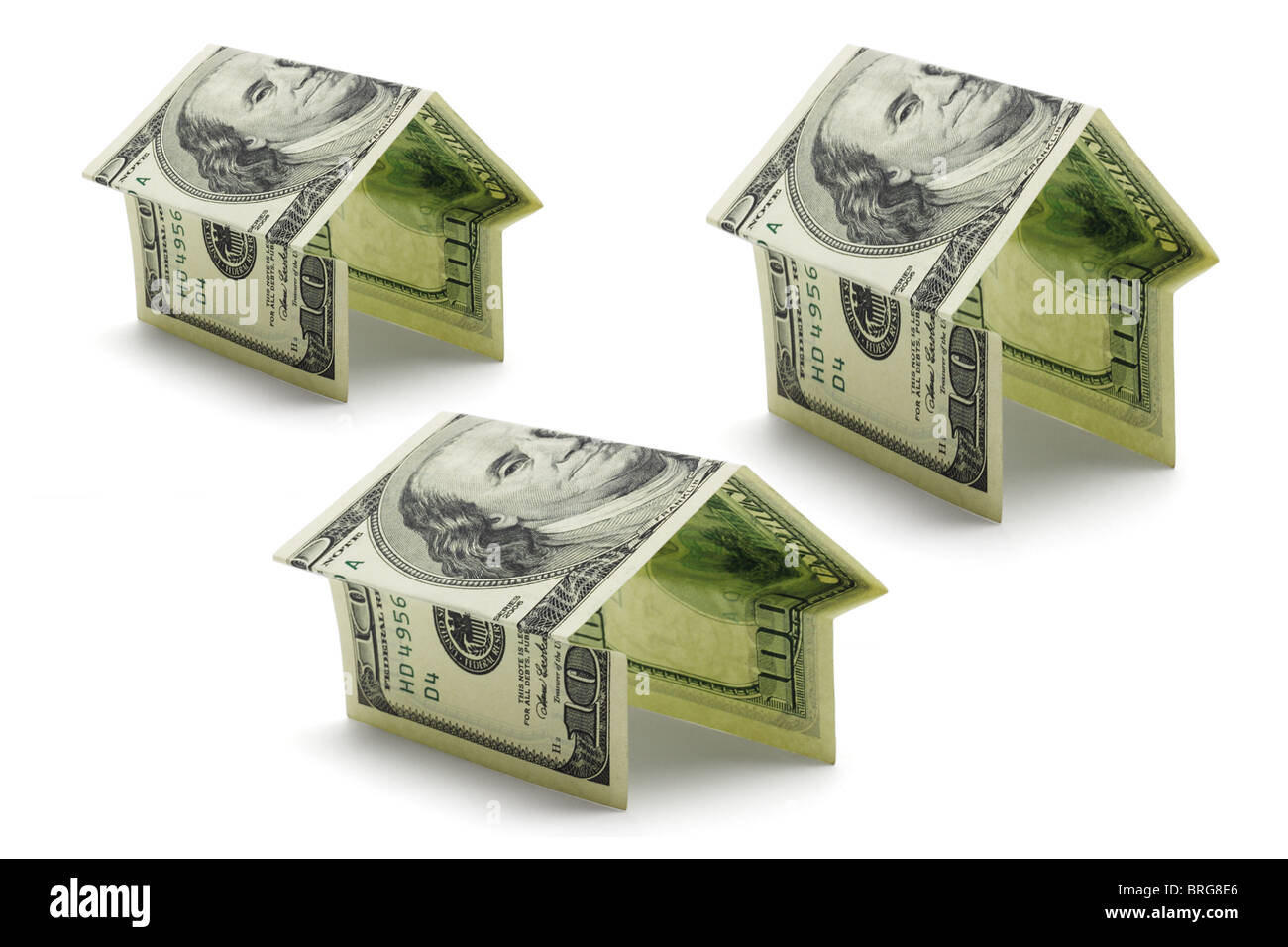 Hundert US-Dollar-Noten gefaltet in verschiedenen Formen und Größen der Häuser auf weißem Hintergrund Stockfoto
