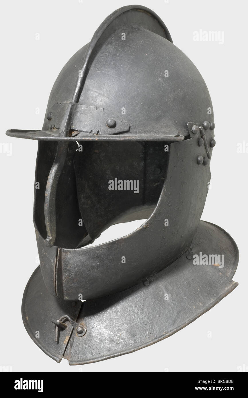 Ein deutscher Kürassier Helm, um 1620 Eisen, geschwärzt Schädel, geschmiedet in zwei Stücke mit einem Kamm und Federnase, schwere feste nasale, genietete Krempe steigt bis zu einem Punkt, große Wangenklappen, die vor dem Gorget mit Haken befestigt werden kann, und genietete Nackenschutz. Unter den Felgen gerollte, von Nieten mit Eisenfutter umgebene Felgen. Alte Schwärzen. Höhe 34 cm. Kleiner Riss auf der linken Seite, sonst in gutem Zustand. Herkunft: Burgsammlung Sigmaringen,Stuker Auktion,Bern 1975. Beeindruckende große cuirassier Helm.,historisch, historisch, 17. Jahrhundert, Verteidigungswaffen, Waffen,, zusätzliche-Rechte-Clearences-nicht verfügbar Stockfoto