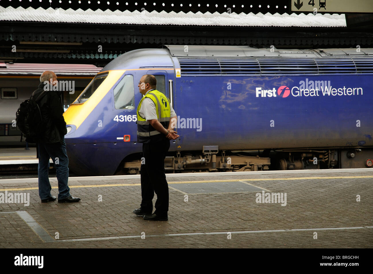 Bahnhof und Zug mit einer Kundenservice-Dispatcher stehen auf der Plattform am Bahnhof Berkshire England lesen Stockfoto