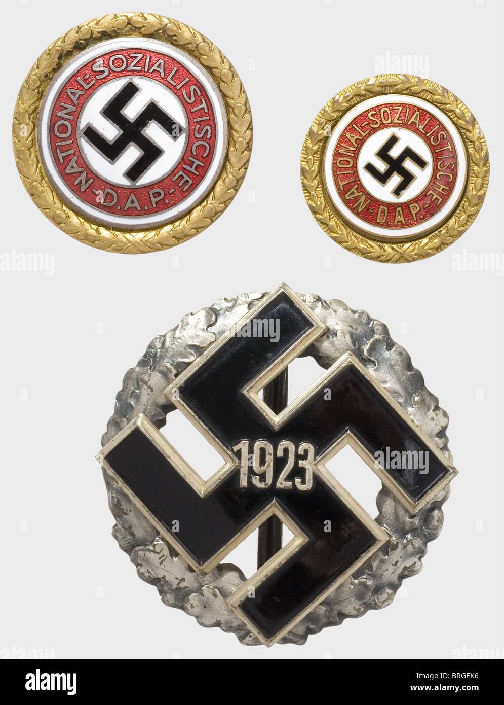 Ein Paar Goldene Parteiabzeichen der NSDAP und ein NSDAP Party District Gedenkabzeichen mit Jahr '1923' beide Parteiabzeichen mit der passenden Nummer '3828', das 30 mm Abzeichen ist vergoldet, versilbert und emailliert mit dem Reverse Maker-Zeichen 'Schler & Sohn - München 9','Ges. Gesch' und Prämiennummer. Das 24 mm Abzeichen (Fuess Type) ist emailliert mit komplett vergoldet, die Rückseite mit Prämiennummer. Das NSDAP Party District Gedenkabzeichen in Silber,Kranz mit Patina und lackiert,genietete Applikationen,Reverse Maker's Mark 'Wächtler & lange Mittweida' und '800' Feinheit,Zusatz-Rechte-Clearenzen-nicht verfügbar Stockfoto