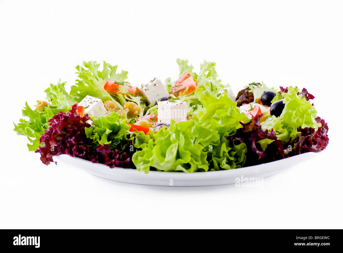 Teller mit frischem Gemüse - Salat, Oliven, Tomaten, Feta und Kräuter Stockfoto