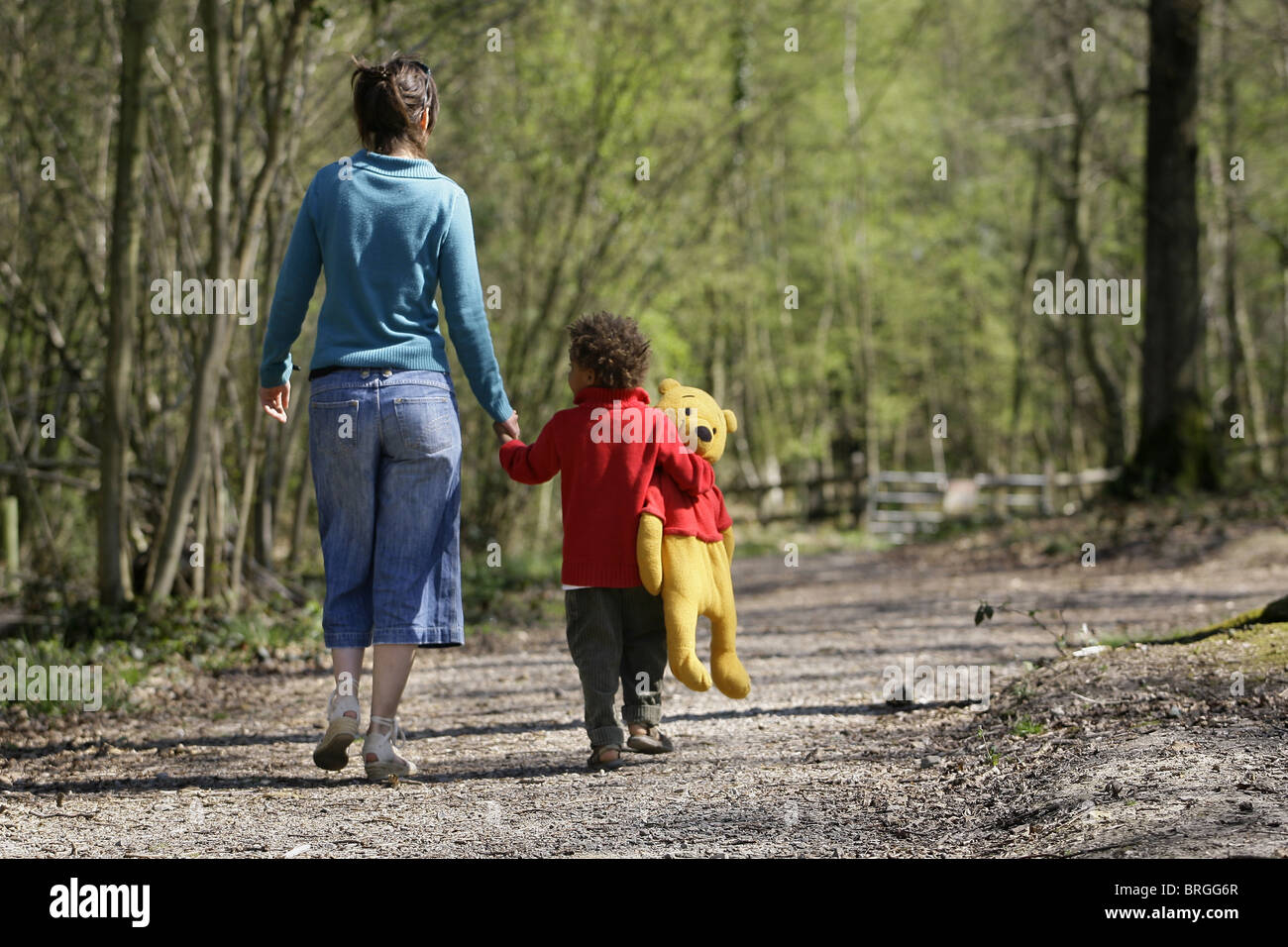 Ein kleiner Junge hält ein Winnie The Pooh, Spaziergänge mit seiner Mutter um Pooh Bridge in der Ashdown Forest. Bild von James Boardman. Stockfoto