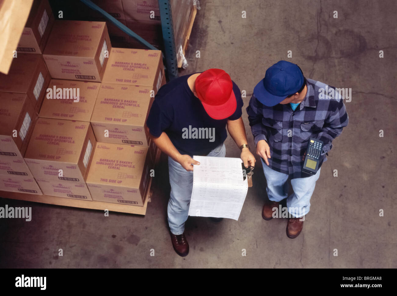 Zwei Arbeiter überprüfen Inventar Blätter im Lager Stockfoto