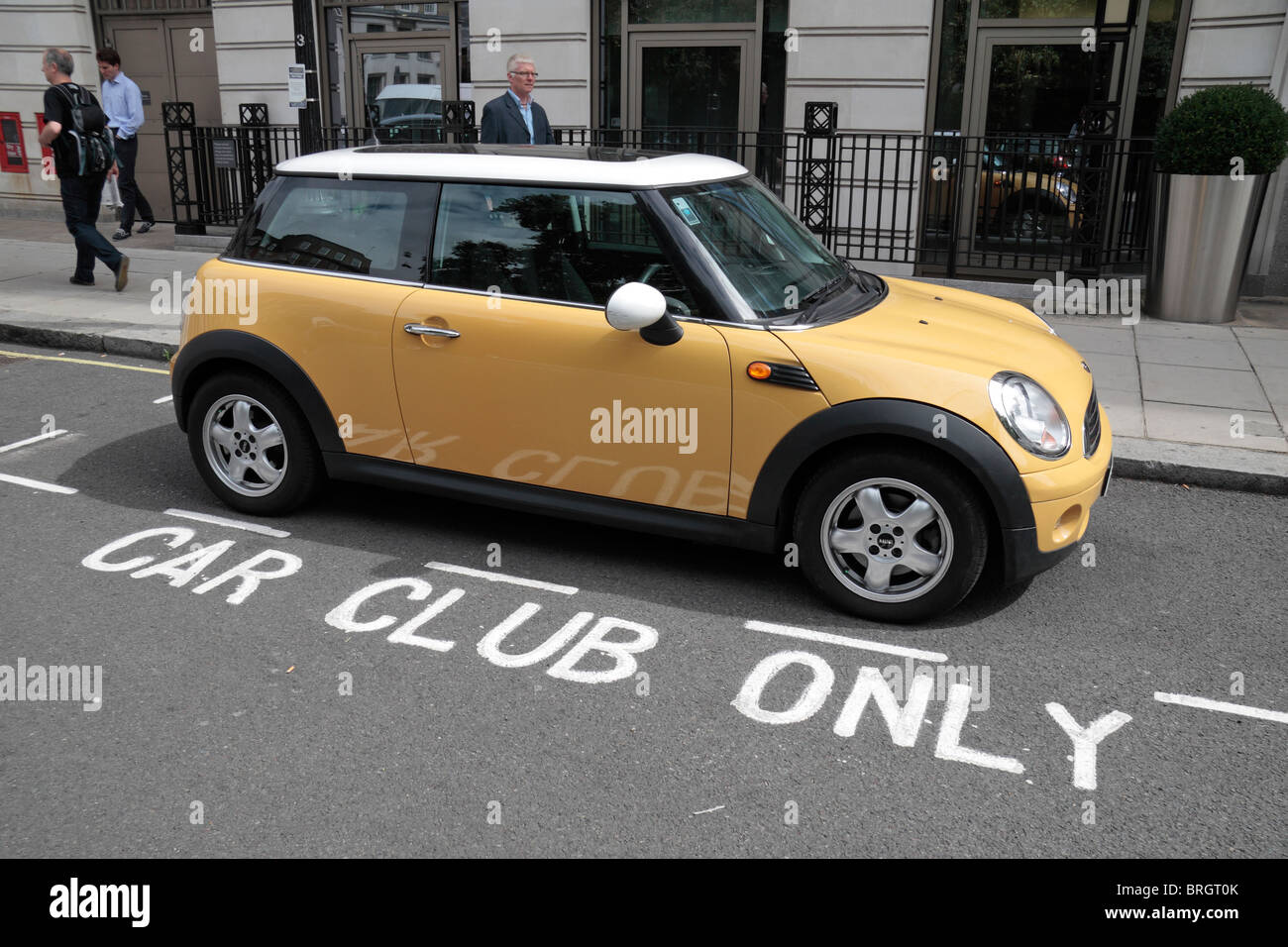 Eine gelbe Mini Cooper in seinen reservierten geparkt Parkplatz Bucht (nur Auto-Club) in London, Vereinigtes Königreich. Stockfoto