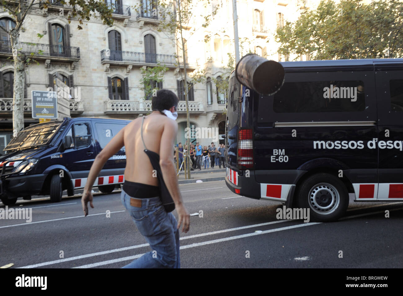 Ein Aktivist anti-System wirft ein Papierkorb gegen einen Polizeiwagen bei in der Innenstadt von Barcelona während des Streiks Auseinandersetzungen. Stockfoto