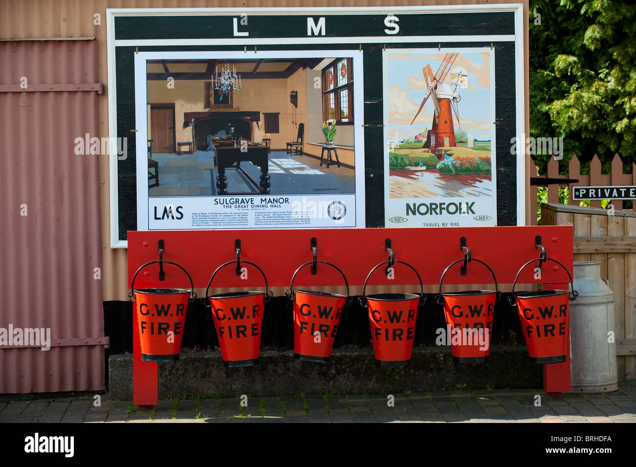 Feuer-Eimer und Werbeplakate an Hampton Loade Station in der Nähe von Bridgnorth, Shropshire Stockfoto