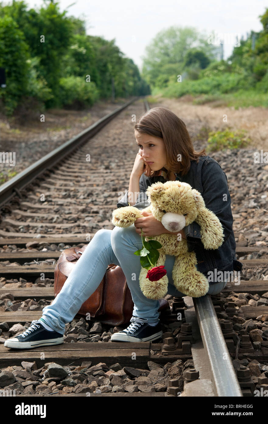Teenager-Mädchen sitzen auf Schienen Stockfotografie - Alamy