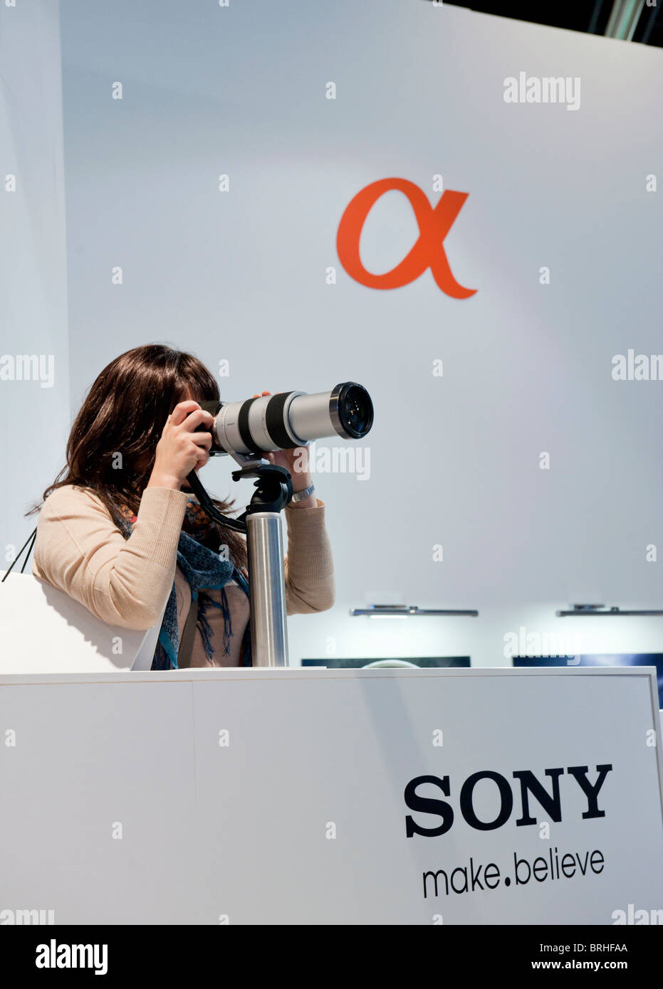 Weibliche Besucher, die mit Sony-Kamera und Objektiv auf der Photokina digital-imaging-Messe in Köln Stockfoto