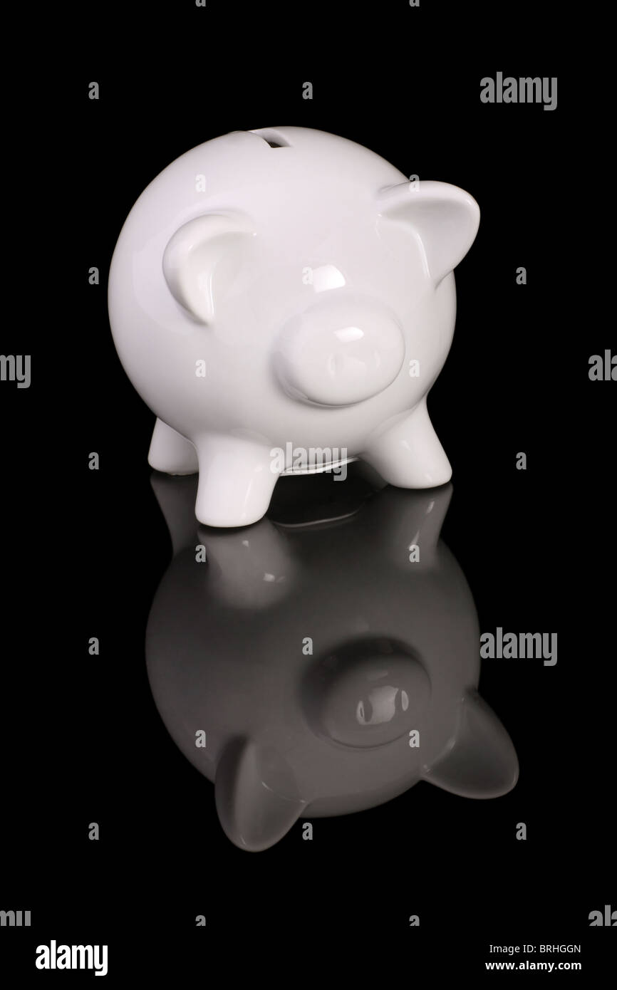 Schwein Spardose auf einer schwarzen reflektierenden Oberfläche geformt. Stockfoto