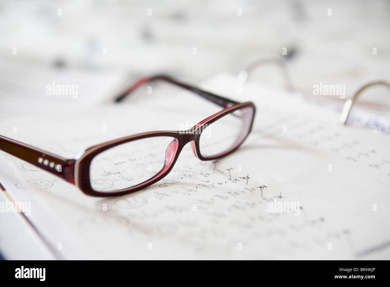 Nahaufnahme von Brillen auf Mathe-Hausaufgaben Stockfoto