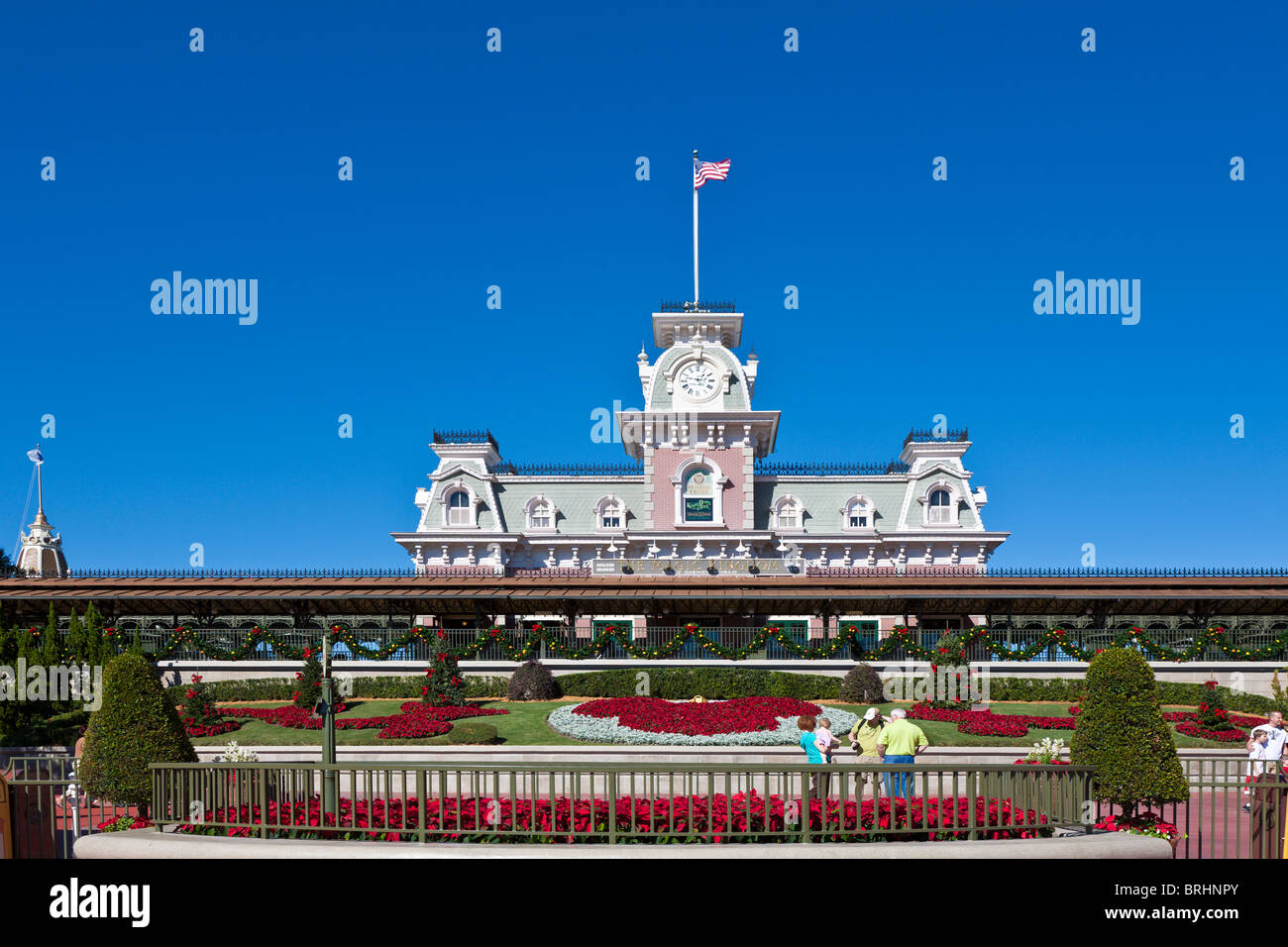 Park-Gäste-Pose für Bilder nahe dem Eingang zum Magic Kingdom in Disneyworld, die für Weihnachten dekoriert ist Stockfoto