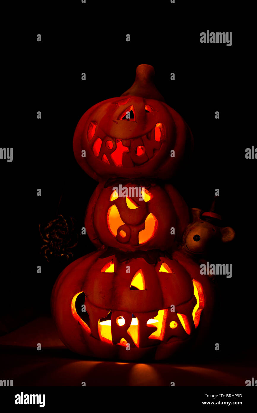 Stapel von Halloween Kürbisse ornament leuchtet im Inneren durch Tee Licht und spiegeln die Phrase Trick oder Festlichkeit Stockfoto