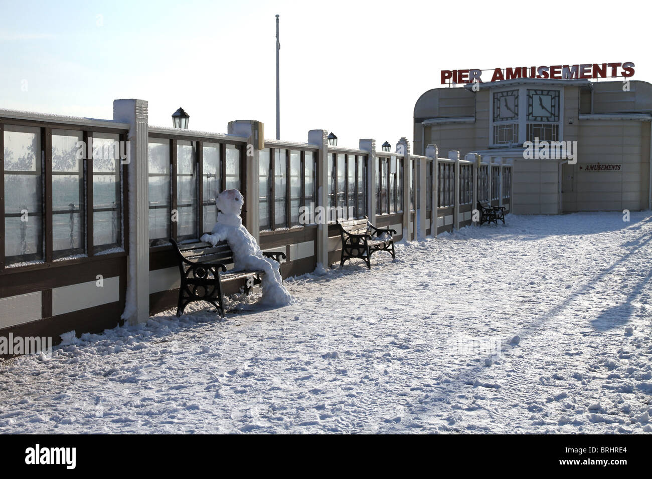 Ein Schneemann entspannend auf einer Bank auf Worthing Pier. Stockfoto