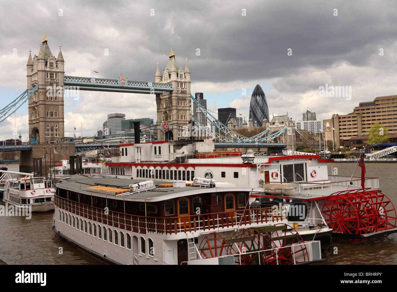 Blick auf die Tower Bridge von Butlers Wharf mit dem Fluss und die Boote in den Vordergrund, Southwark, London, SE1. Stockfoto