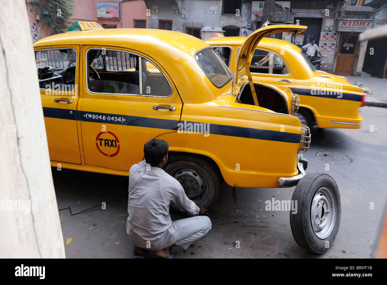 Länder Südasiens Indien Kalkutta Kalkutta, Taxifahrer Reparatur eine Kabine mit platten Reifen, Botschafter, die auf dem britischen Morris Oxford Modell beruht Stockfoto