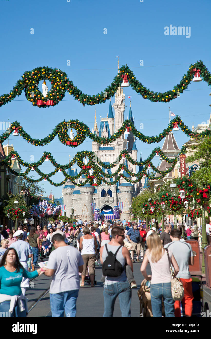 Parkgäste drängen Main Street mit obenliegenden Kränzen und Weihnachtsschmuck im Magic Kingdom im Walt Disney World Stockfoto