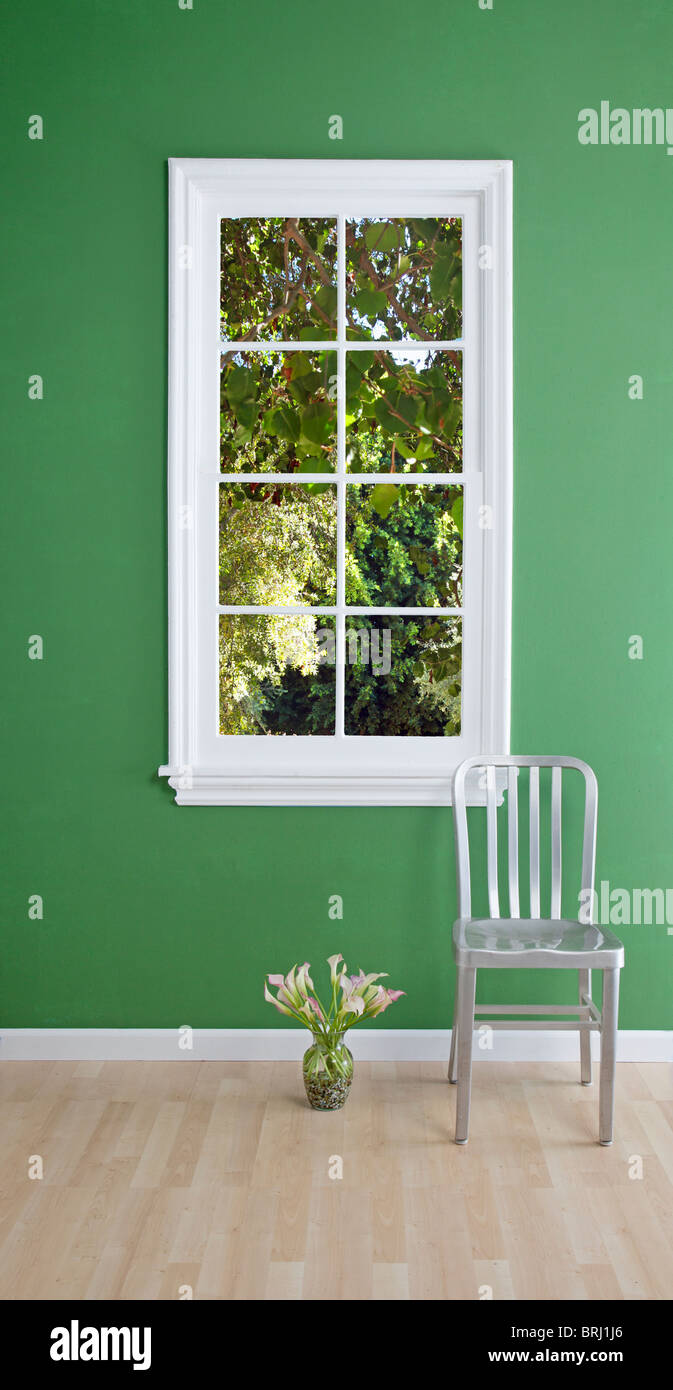 Stuhl und Blumen am Fenster Stockfoto