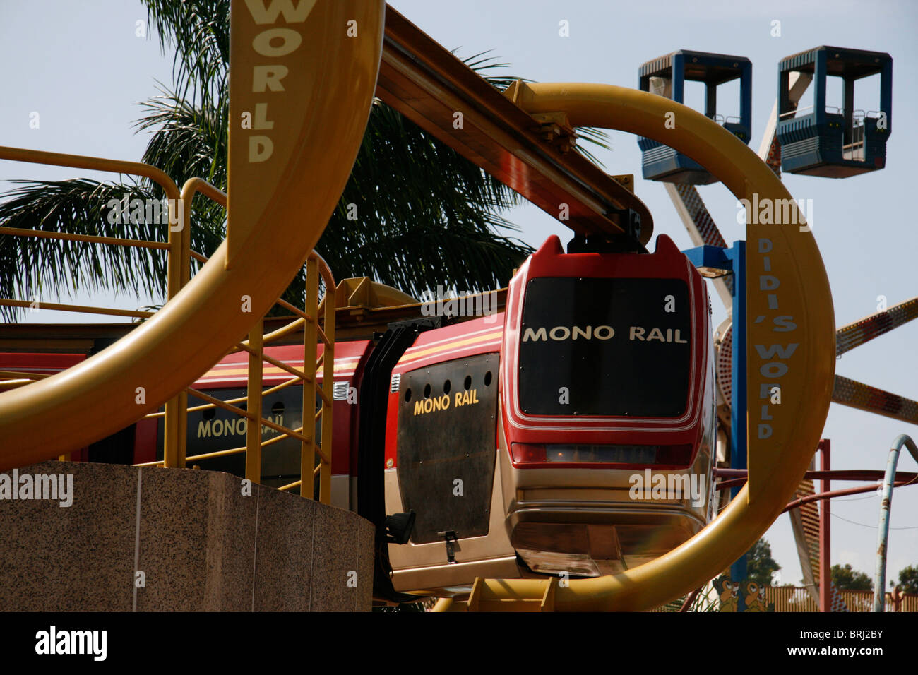 Ein mono Rail-Spritztour in einem Vergnügungspark mit einem Riesenrad im Hintergrund Stockfoto