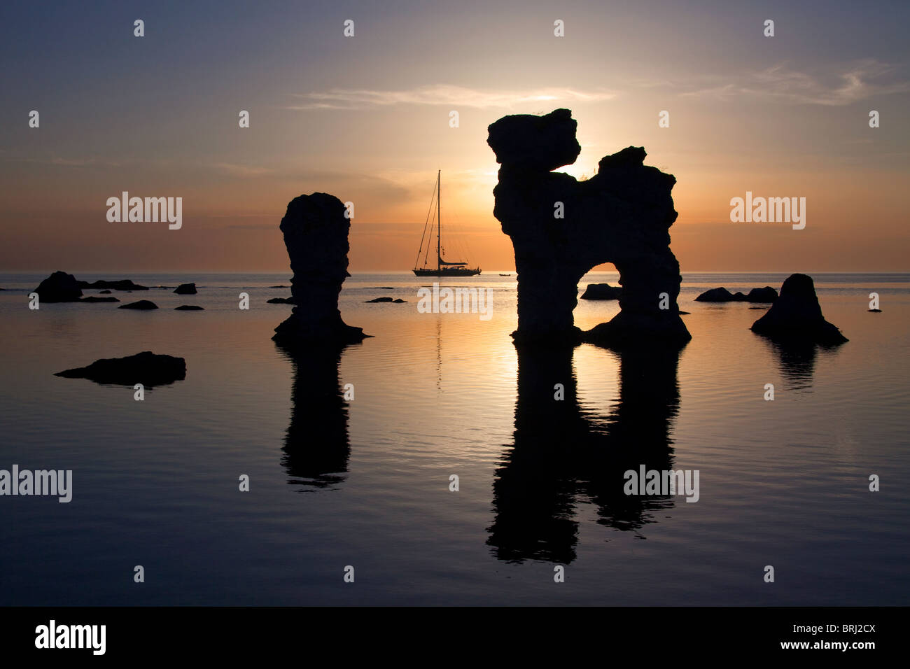 Segelschiff und erodierten Seastacks in Gamla Hamnøya bei Sonnenuntergang in Fårö, Schweden Stockfoto