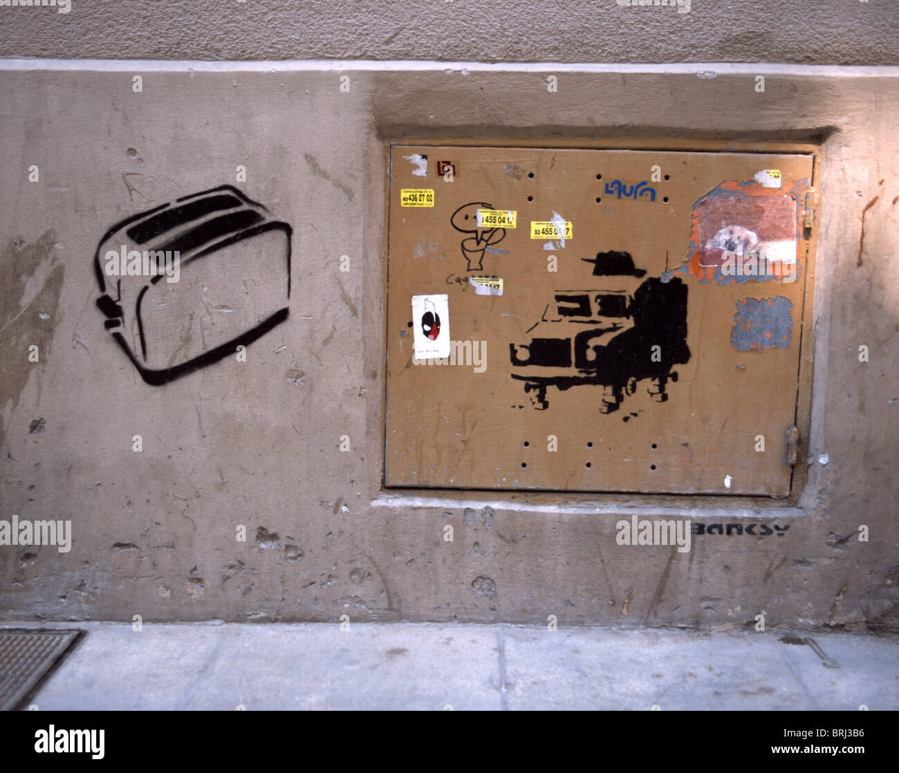 Schablone zeigt ein Toaster und ein gepanzertes Fahrzeug gemacht von Bansky in Barcelona, Spanien Stockfoto