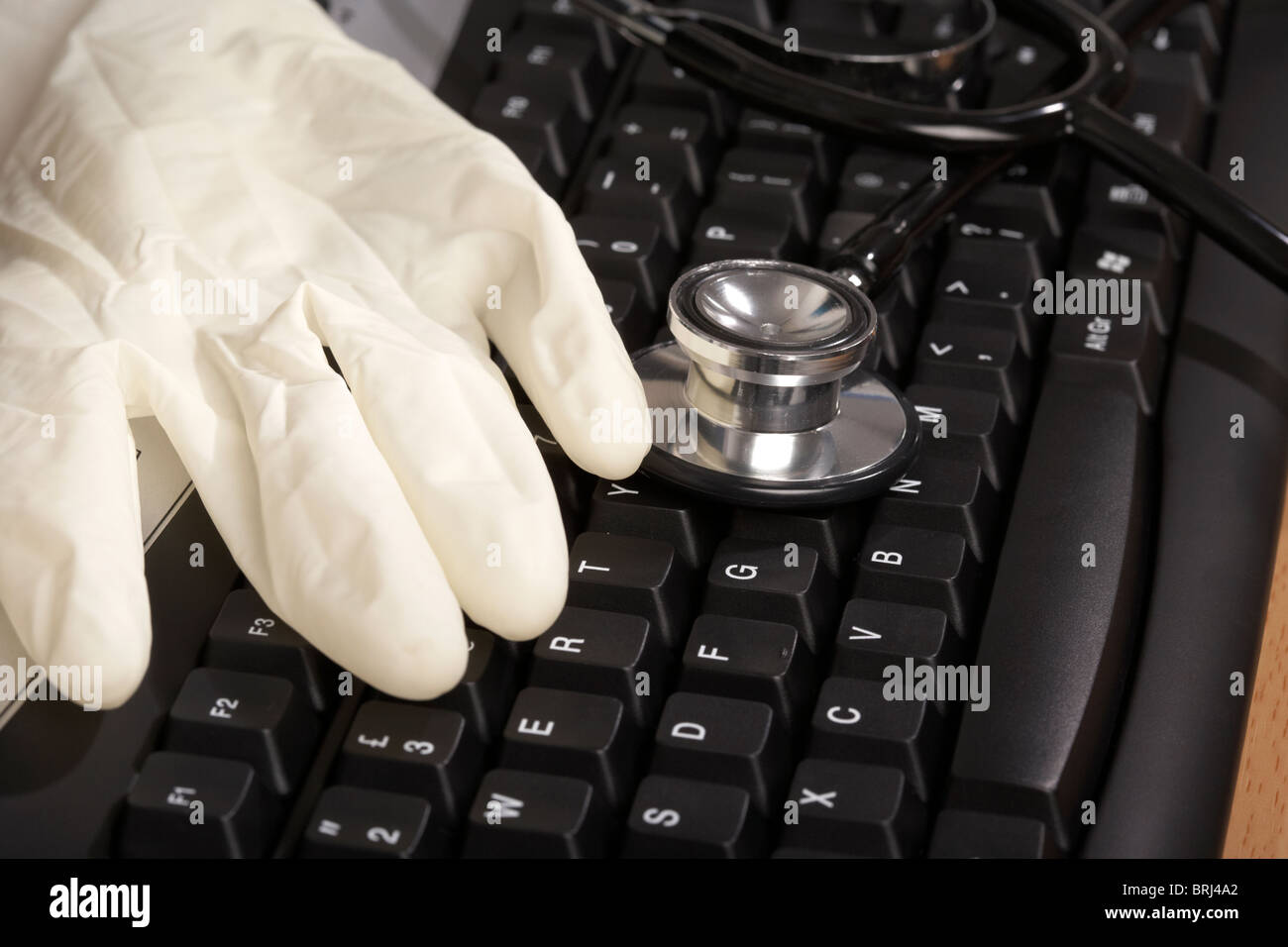 Stethoskop und Kautschuk Handschuh auf einer Computertastatur Stockfoto