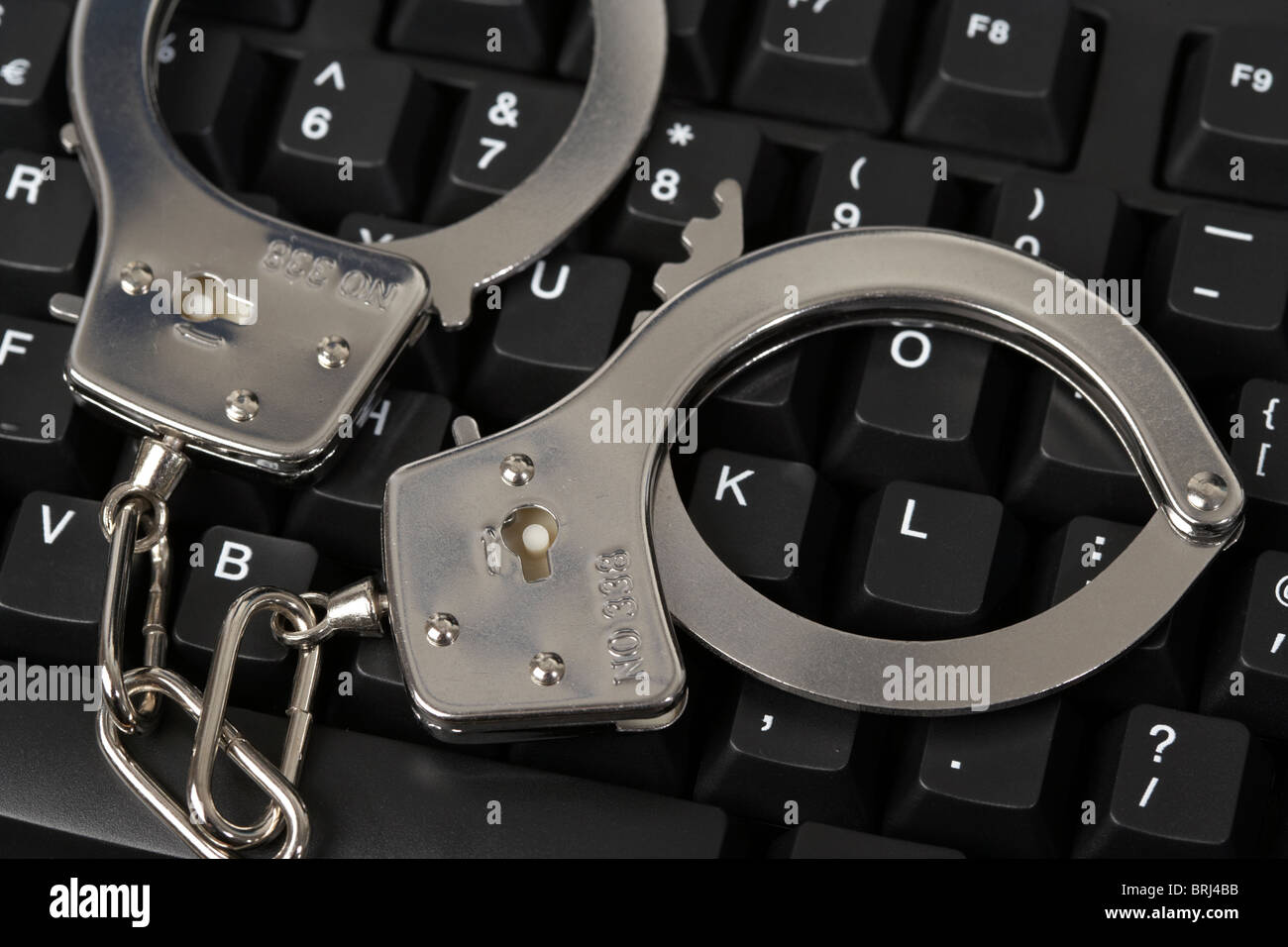 Handschellen auf einer Computertastatur Stockfoto