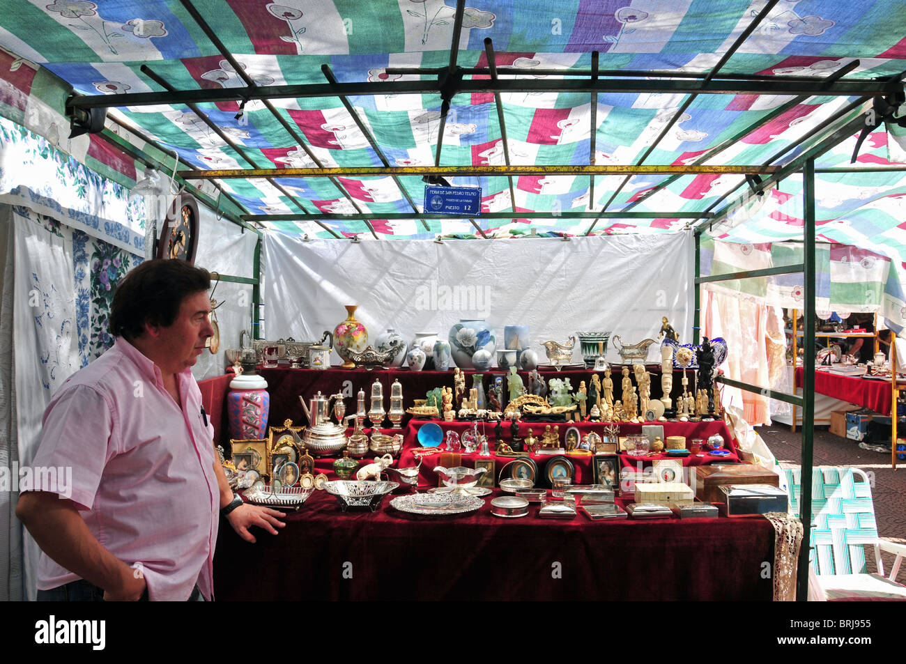 Markt-Stall-Mann verkaufen Schmuck, Besteck, Vasen, Figuren und Miniatur-Malereien, San Telmo Sonntagsmarkt, Buenos Aires Stockfoto