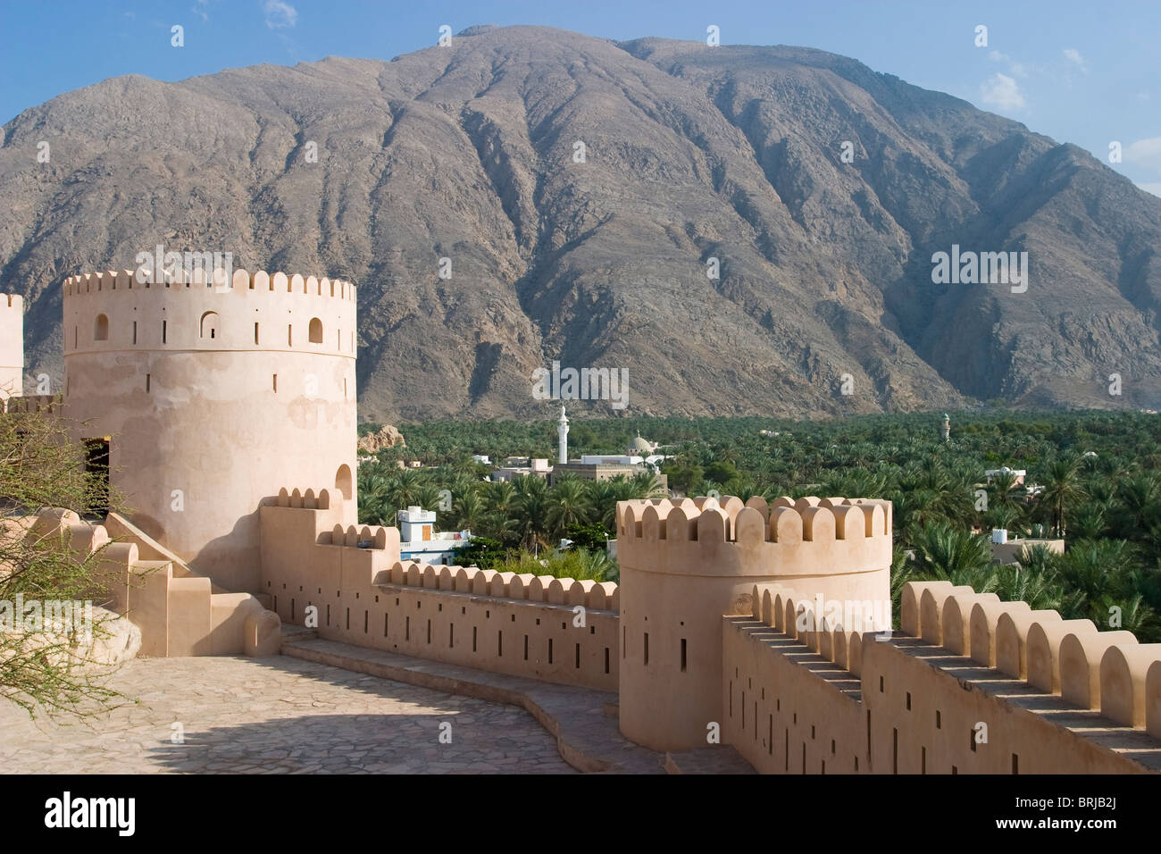 Nakhl Fort mit Moschee und Jebel Akhdar-Bergen im Hintergrund, Oman. Stockfoto