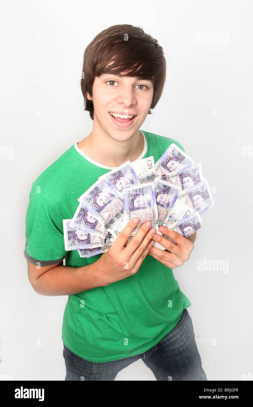 Junge männliche Schüler halten von Bargeld, britische Pfund Stirling. Stockfoto